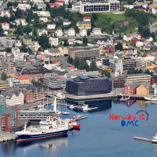 Aerial view of Tromsø city, surrounded by snow-capped mountains and fjords